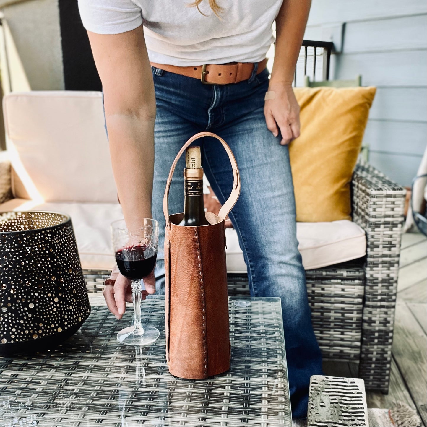 1974 Leather Whiskey & Wine Bottle Tote in HIckory sitting on a coffee table with a glass of red wine