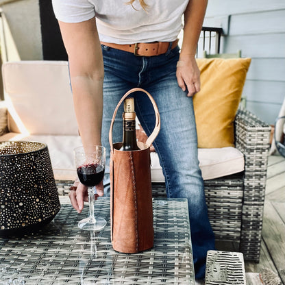 1974 Leather Whiskey & Wine Bottle Tote in HIckory sitting on a coffee table with a glass of red wine